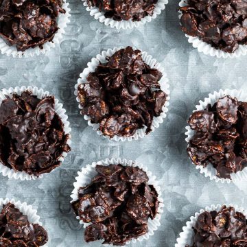 chocolate cornflake cakes in white paper cases on a metal tray.