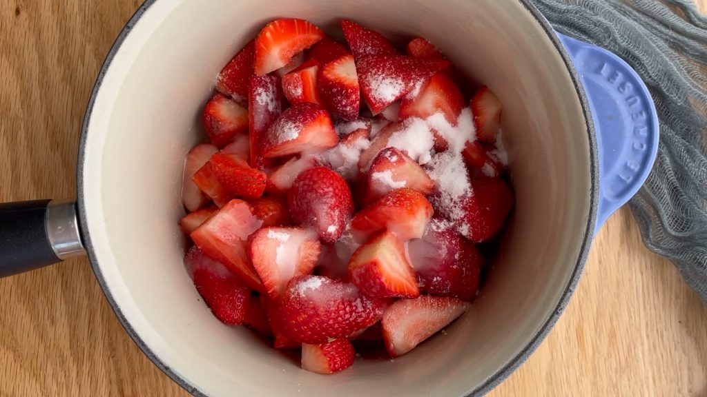 chopped strawberries in saucepan with sugar, lemon juice, vanilla and water