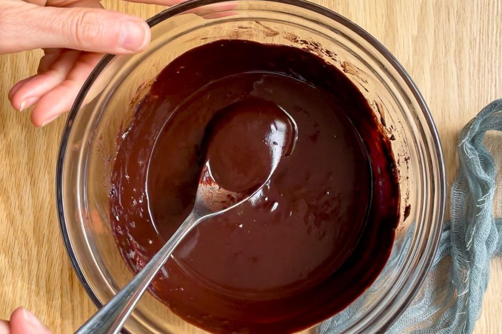 melted chocolate, butter, cocoa and syrup in a bowl to show consistancy