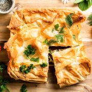 baked silverbeet hortopita decorated with fresh herbs and edible flowers