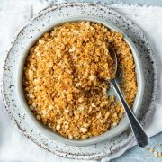 pangrattato in a blue dish with a spoon in the bowl.