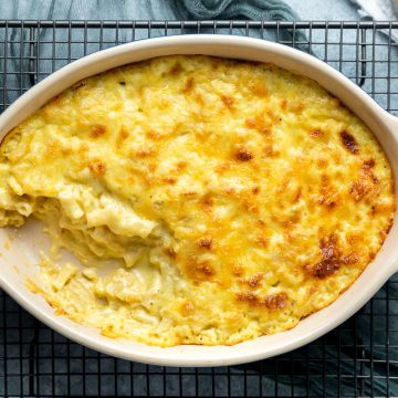 baked macaroni and corn casserole in a baking dish with a portion taken out.