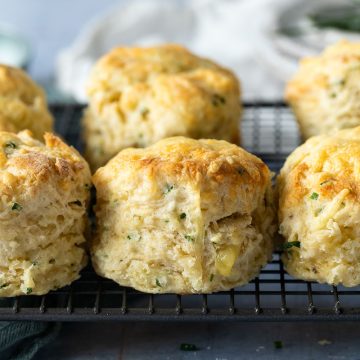 side view of 3 cheese and chive scones on a metal cooling rack.