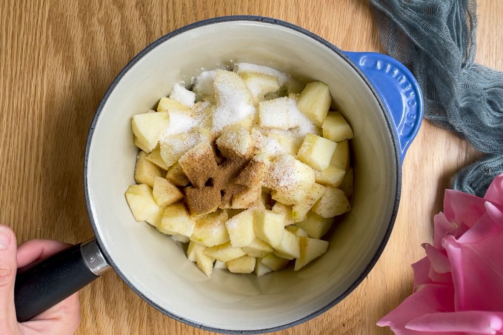 chopped apples with sugar, water and cinnamon in a saucepan.