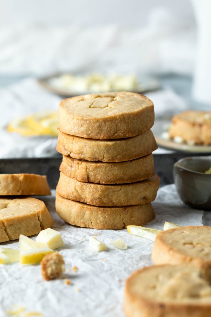 stack of 5 lemon chocolate cookies, with crumbled white chocolate scattered around the base.
