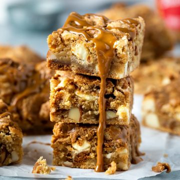 Close up of a stack of Biscoff blondies topped with biscoff spread.