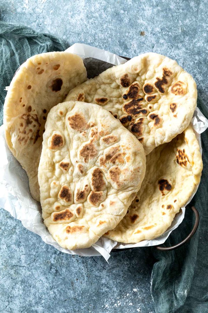 homemade naan served on a metal tray.