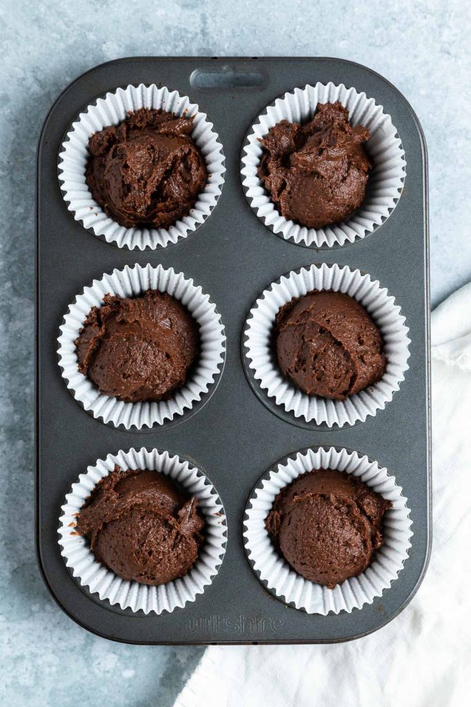 The chocolate orange cupcake batter in paper cases ready to bake.