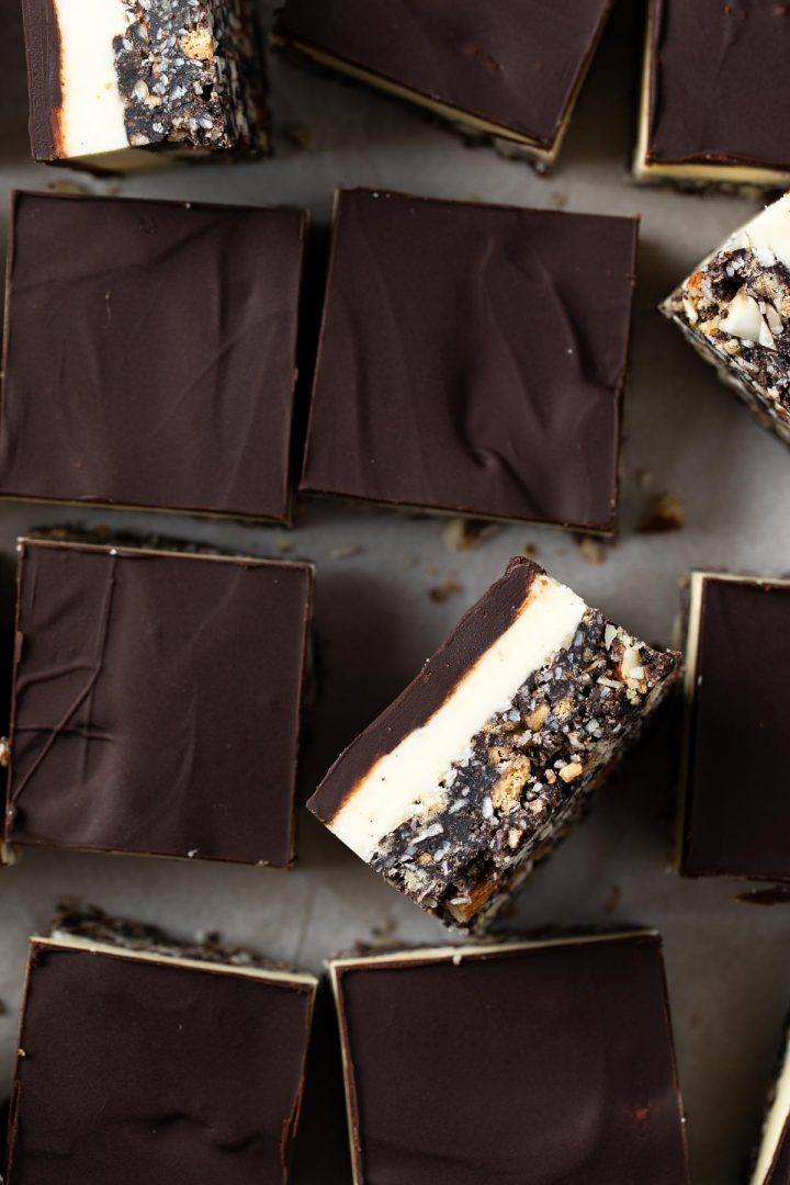 close up of Nanaimo bars, with one on it's side to show the 3 layers.