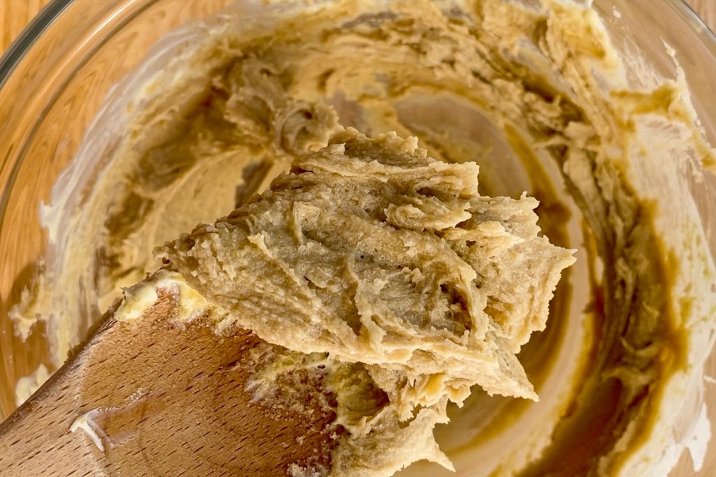A spoon holding up the butter once all the brown sugar has been added.
