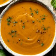 Carrot and coriander soup in a bowl sprinkled with fresh coriander.