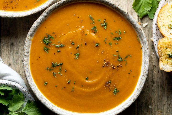 Carrot and coriander soup in a bowl sprinkled with fresh coriander.