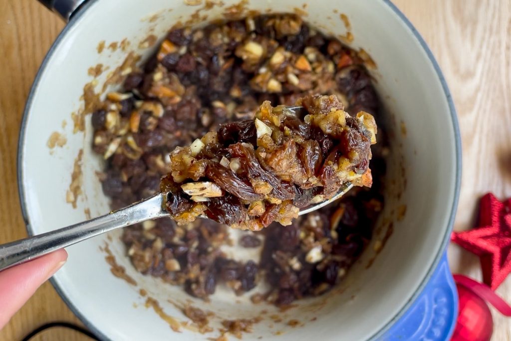 A spoon holding up a spoonful of the cooked fruit mince.