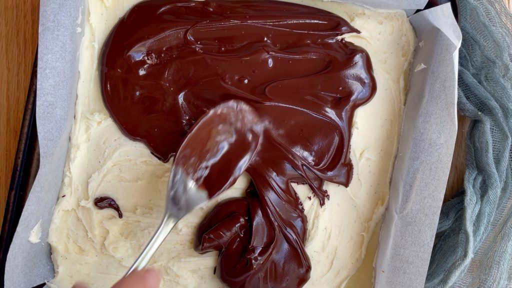 Spreading the melted chocolate over the half frozen buttercream.