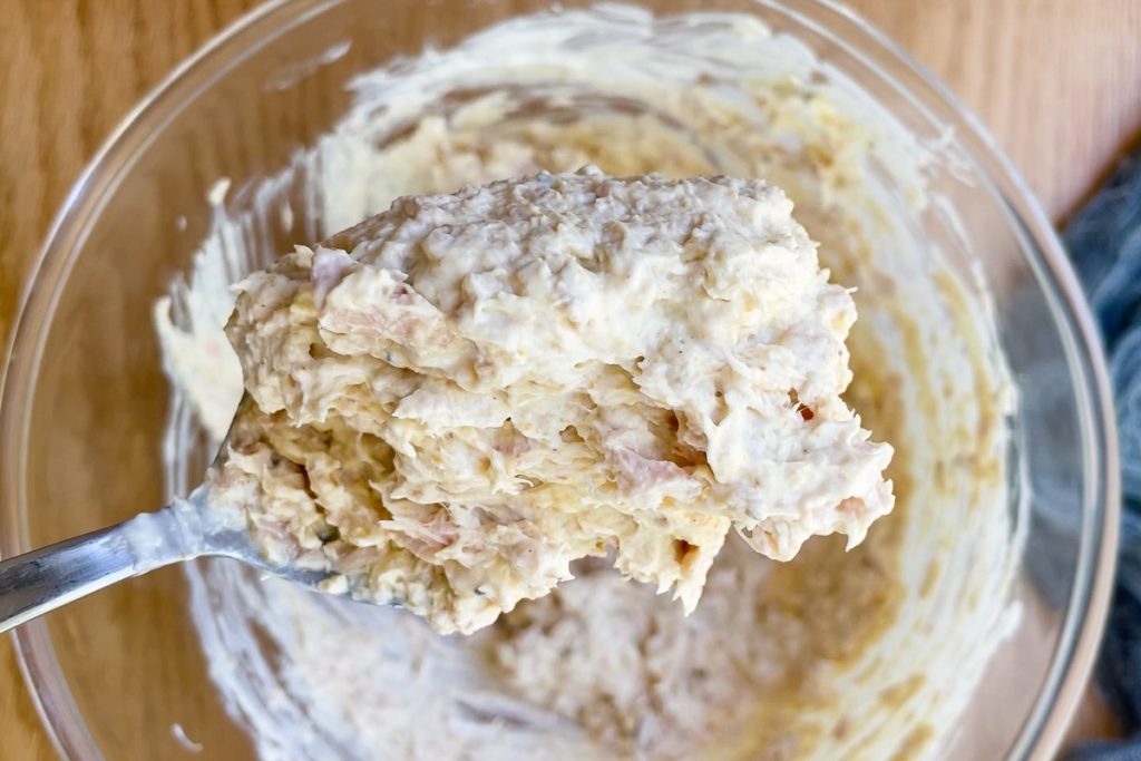 A spoon holding up the finished dip to show the consistency.