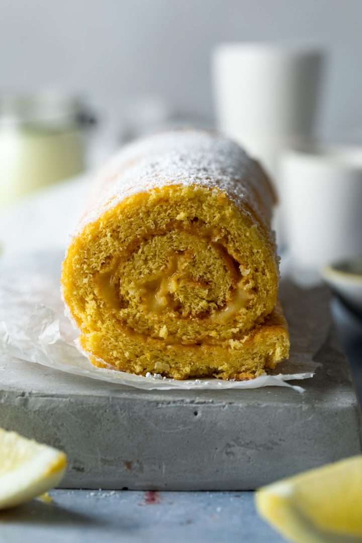 Side view of a cut lemon swiss roll to show the swirl.