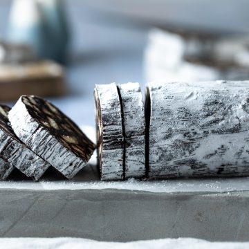 Side view of Portuguese chocolate salami with the left hand side sliced into slices.