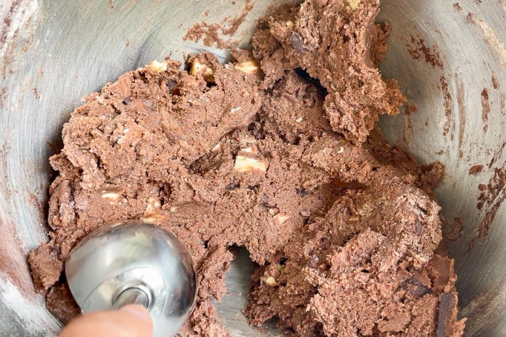 The finished cookie dough being scooped up with an ice cream scoop.