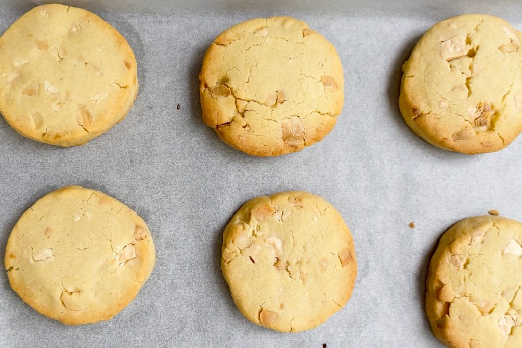 The freshly baked cookies on the lined baking tray.