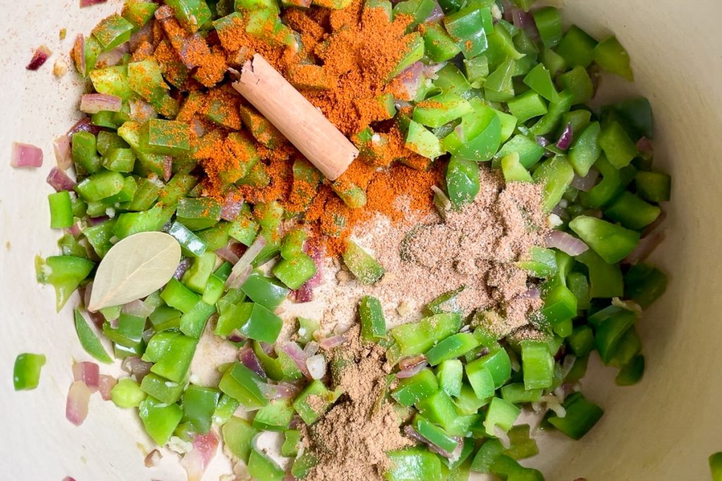 Green capsicum / pepper added to the onion along with spices.
