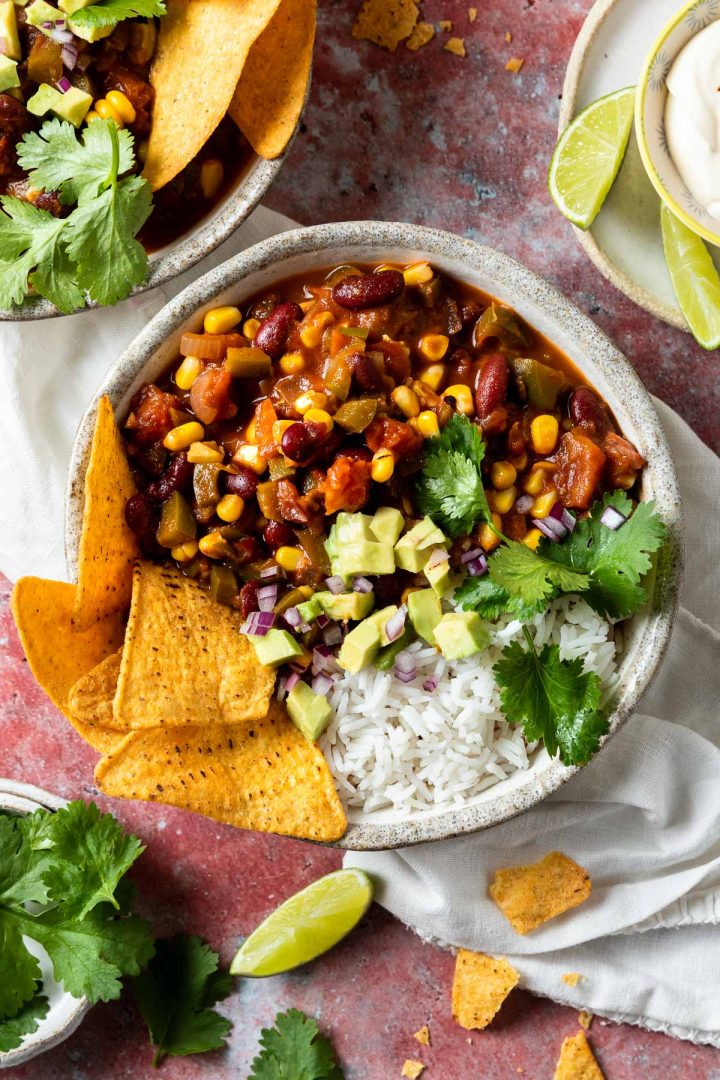 A bowl of vegetarian chilli sin carne served with rice, topped with avocado and fresh coriander.