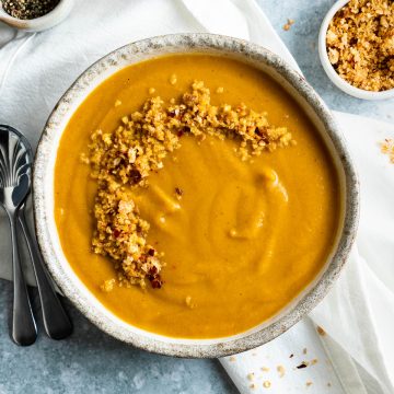 A bowl of winter vegetable soup topped with Italian breadcrumbs.