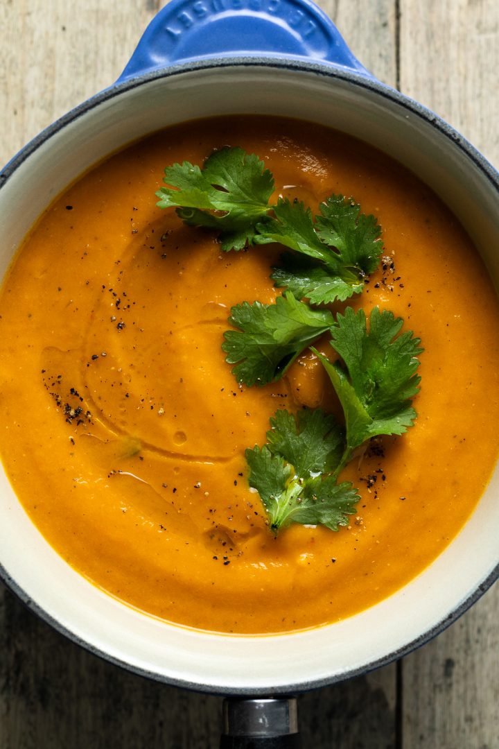 Finished carrot and lentil soup in a blue saucepan.
