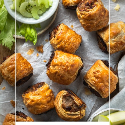 Cheese and pickle sausage rolls on a wooden board with celery and apple.