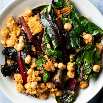 Silverbeet (Swiss chard) and chickpeas on a white serving plate.