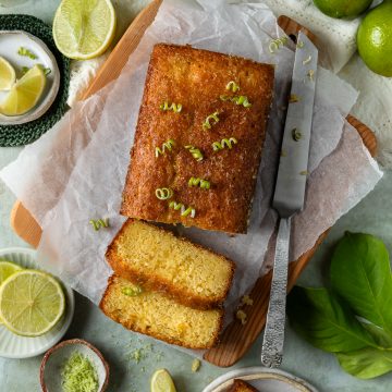 Sliced lime drizzle cake topped with fresh lime zest.