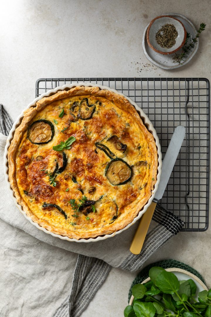 The baked courgette quiche on a wire coolign rack.