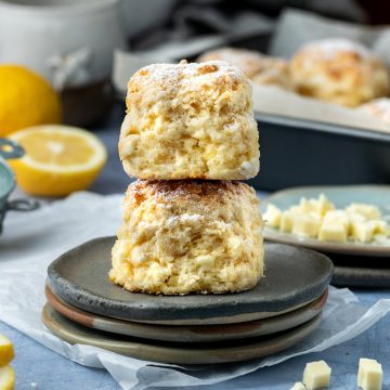 Two lemon white chocolate scones stacked on 3 plates.
