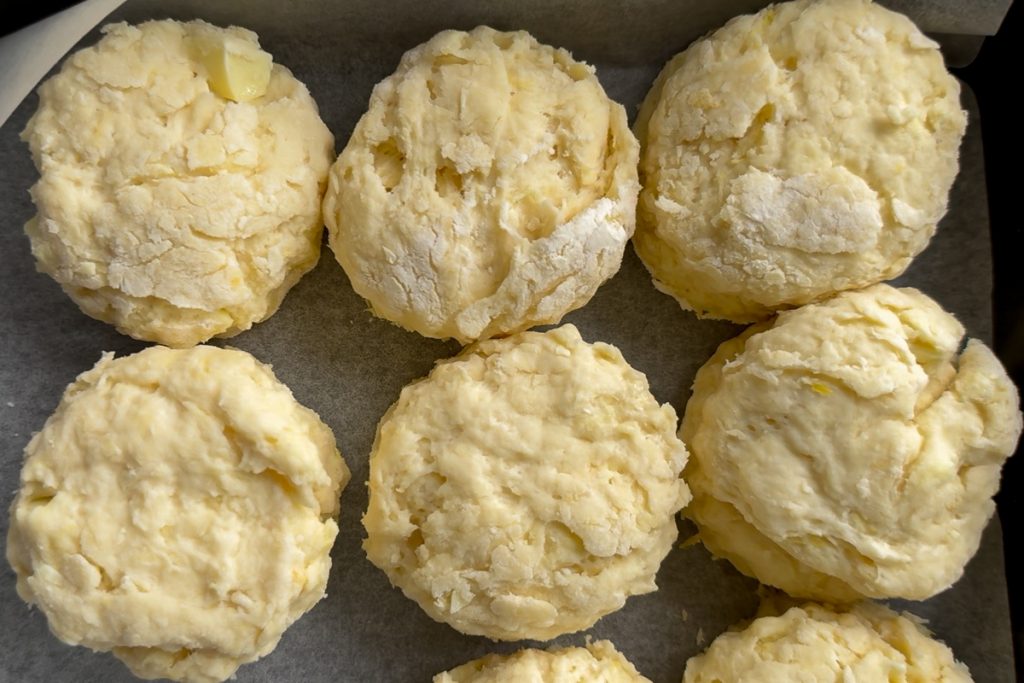 The scones in a lined baking tin, just touching to help them to rise.