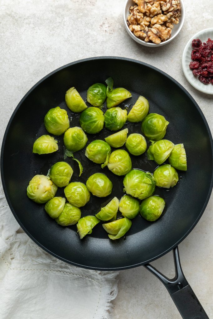 The blanched Brussels sprouts cut side down in a frying pan.