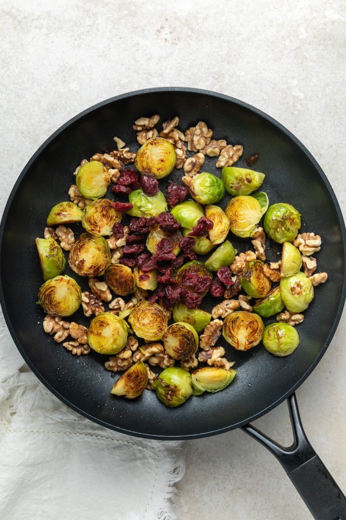 Dried cranberries added to the pan.