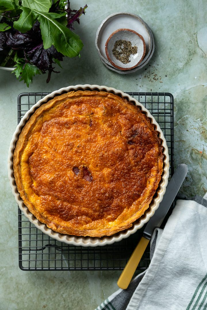 The baked quiche lorraine on a cooling rack.