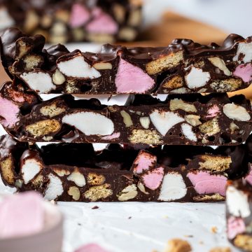 A stack of 3 pieces of dark chocolate rocky road.
