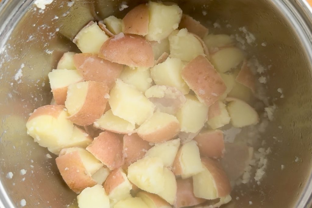 The partly cooked potato cubes after being shaken in the pan to rough up the edges.