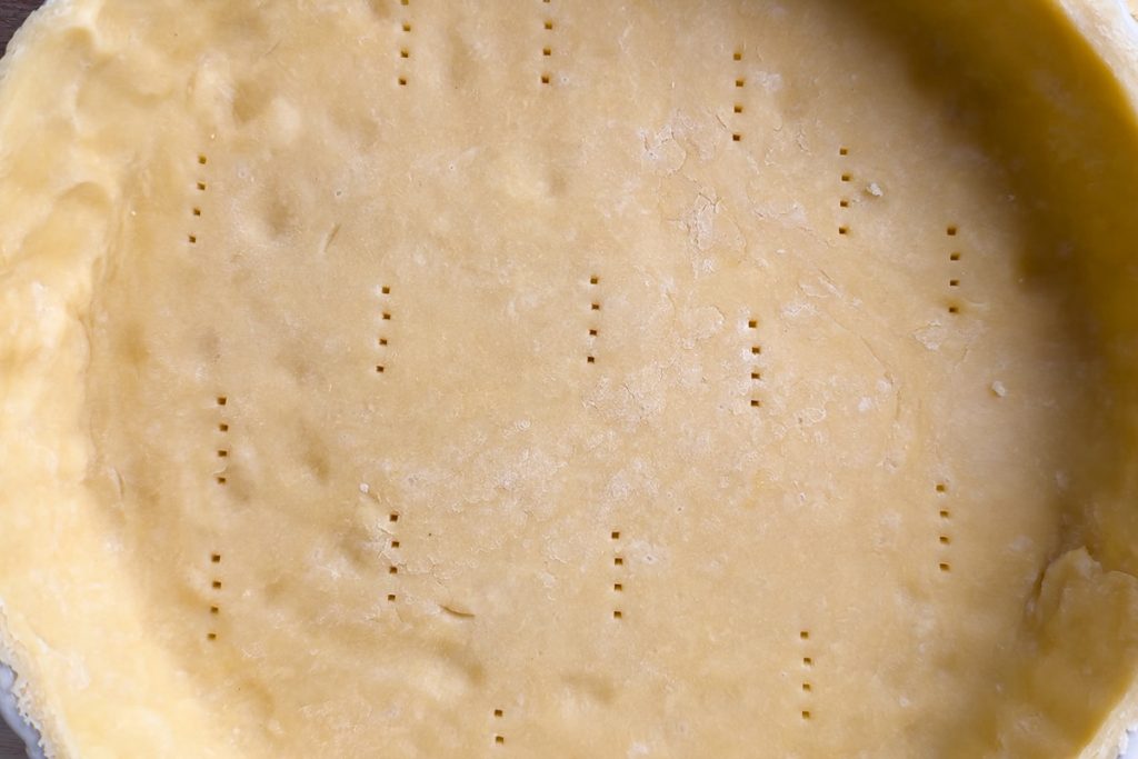 The quiche tin lined with the pastry, pricked with a fork and the edges trimmed with a sharp knife.