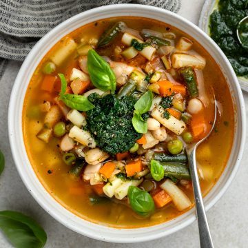 A bowl of pistou soup served with extra basil pistou.