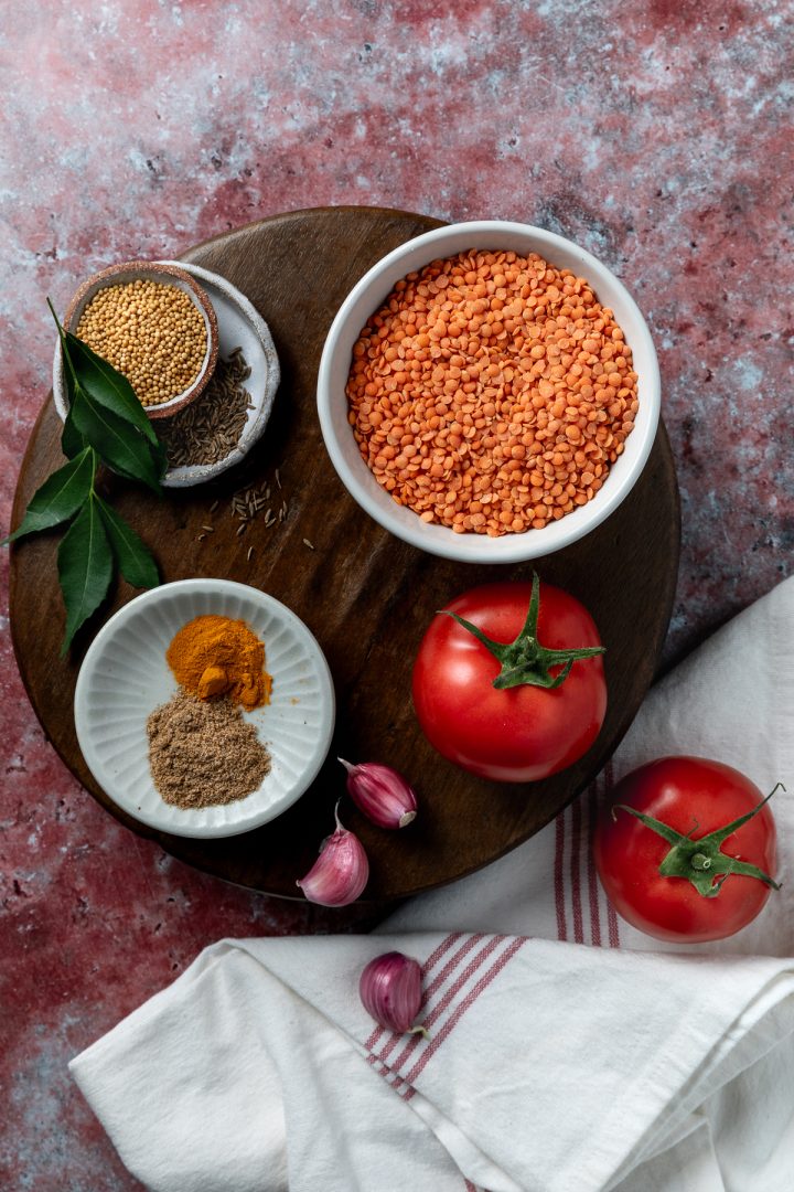 The ingredients needed to make the curry on a dark wooden board.
