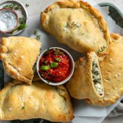 A plate of silverbeet calzone, with tomato dipping sauce.