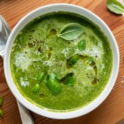 A bowl of silverbeet soup sprinkled with grated parmesan cheese and fresh basil.