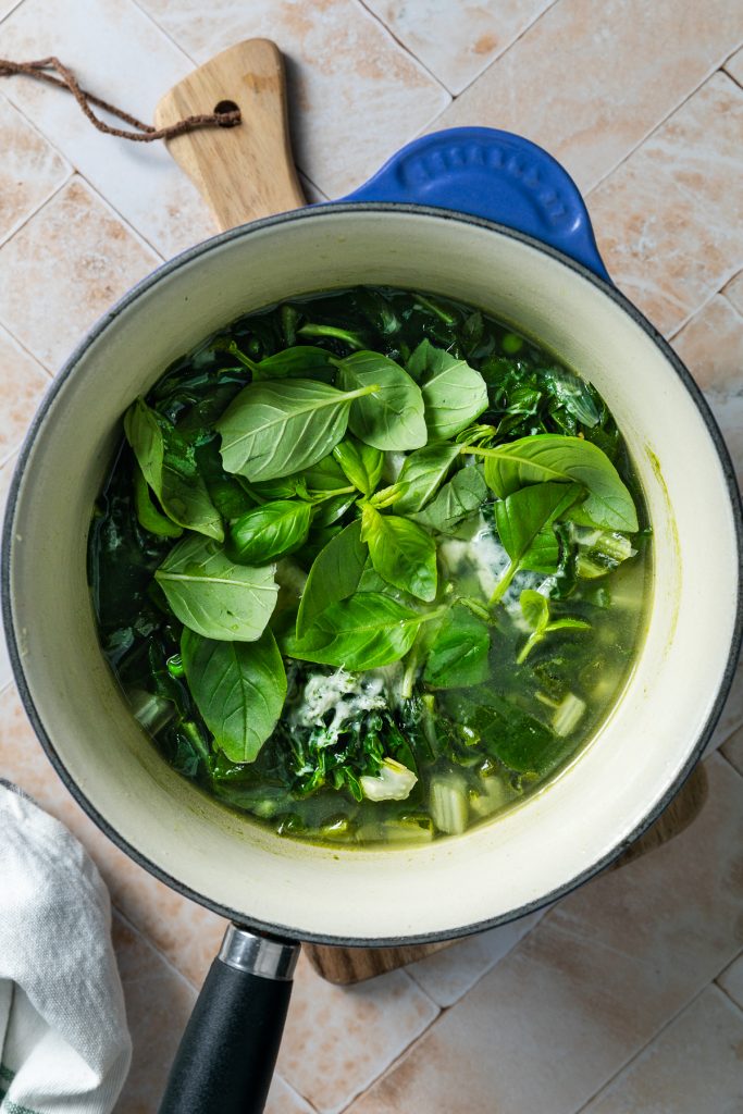 The cooked vegetables and stock in a saucepan.