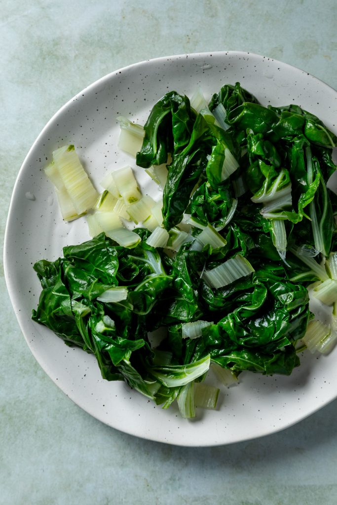The wilted silverbeet leaves and stalks on a plate.
