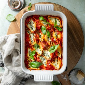A white dish of baked pasta shells stuffed with ricotta.
