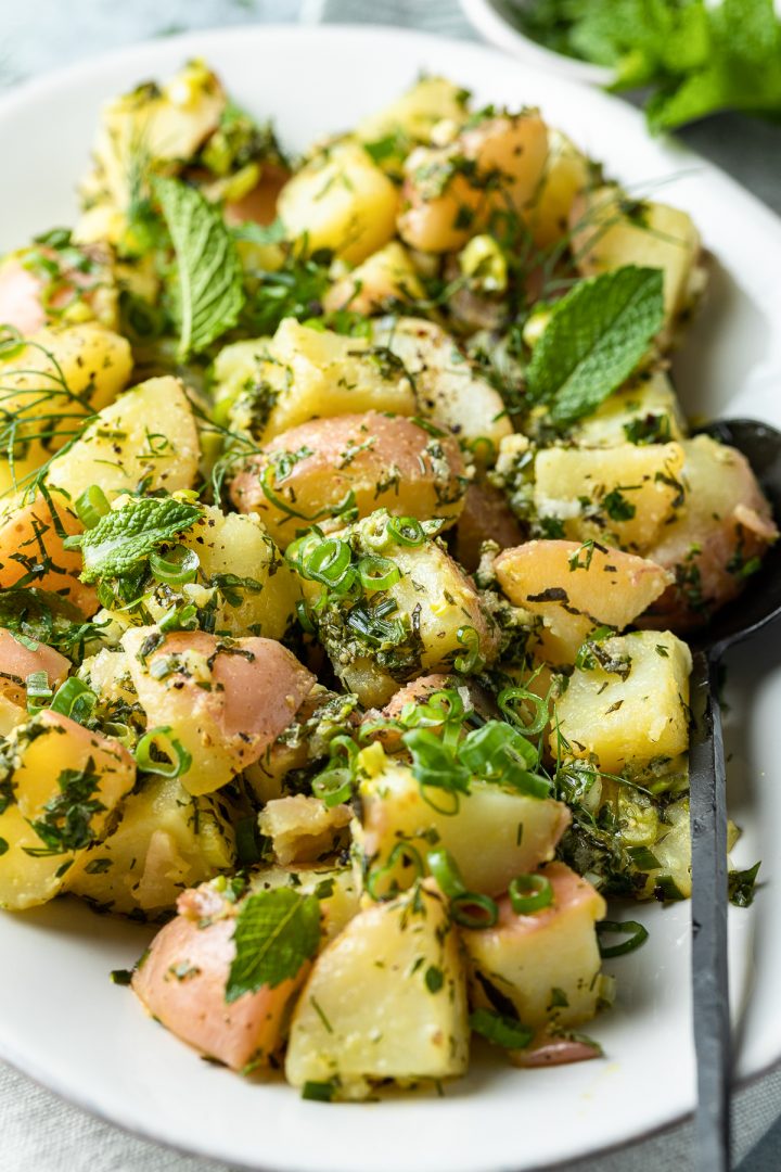 Close up of the chunks of cooked potatoes covered in the fresh herb vinaigrette.
