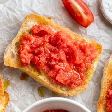 Spanish tomato bread, pan con tomate, on a white background.