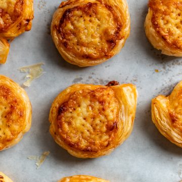Baked cheese and tomato pinwheels on a baking tray.