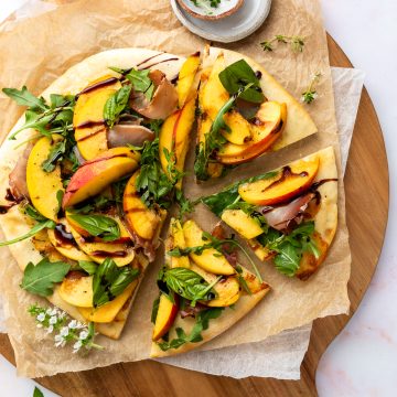 The peach and prosciutto pizza topped with rocket and drizzled with balsamic vinegar.